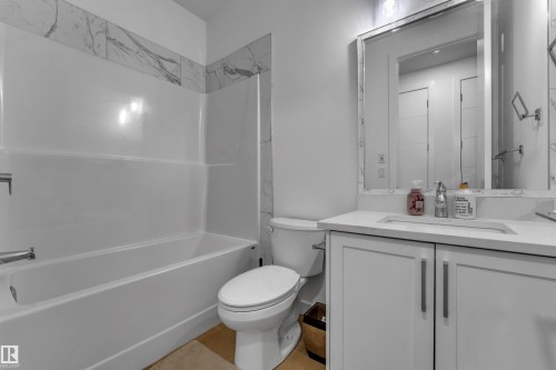 White shaker-style vanity with brushed nickel hardware, integrated sink, and light-toned countertop - 1409 Graydon Hill Way Sw, Edmonton, AB 