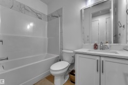 White shaker-style vanity with brushed nickel hardware, integrated sink, and light-toned countertop - 