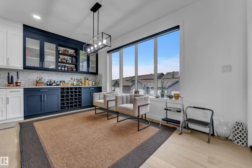 Built-in cabinetry with glass-front upper cabinets, integrated wine storage, and a tiled backsplash - 1409 Graydon Hill Way Sw, Edmonton, AB 