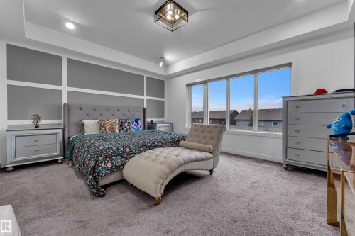 Recessed lighting, large multi-pane window, tray ceiling, wall paneling, and carpet flooring - 1409 Graydon Hill Way Sw, Edmonton, AB 