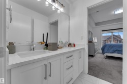 Dual vanity with integrated sinks, ample counter space, white cabinetry, and brushed nickel hardware - 