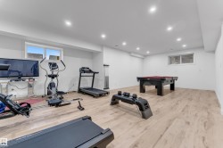 Spacious room with light wood-finish flooring, recessed lighting, and white walls - 