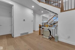 Wood-finish flooring, recessed lighting, white interior doors, and a wood and metal staircase - 