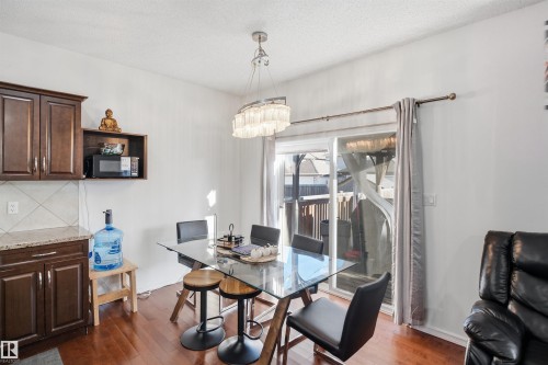 Hardwood-finish flooring, built-in cabinetry, granite-look countertops, tiled backsplash, and sliding glass door - 1523 36 Avenue Nw, Edmonton, AB 