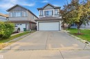 Two-story residence featuring a two-car garage, concrete driveway, and landscaped front yard with mature trees - 1523 36 Avenue Nw, Edmonton, AB 