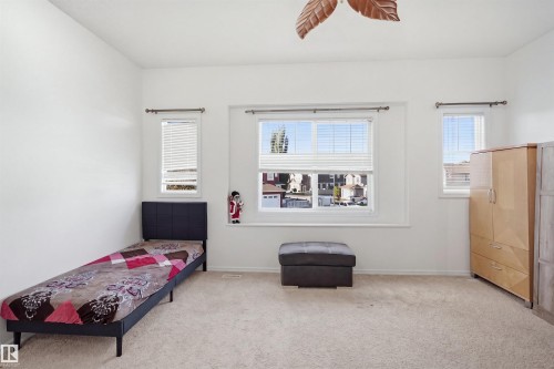 Carpeted room featuring multiple windows with blinds, a ceiling fan, and white walls - 1523 36 Avenue Nw, Edmonton, AB 