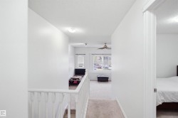 Staircase featuring white balusters and carpeted treads - 