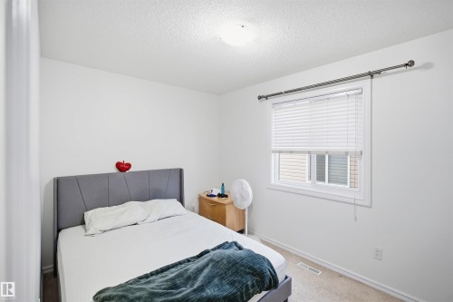 Carpeted bedroom with a single window and ceiling-mounted light fixture - 1523 36 Avenue Nw, Edmonton, AB 