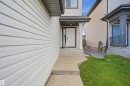 White siding exterior with dark trim accents, concrete walkway, and a covered entry - 1523 36 Avenue Nw, Edmonton, AB 