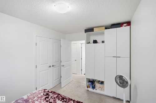 Wall-to-wall carpeting with a white painted finish, flush-mount ceiling lighting, and panel doors - 1523 36 Avenue Nw, Edmonton, AB 