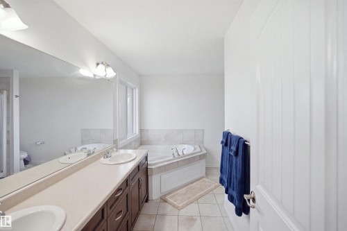 Dual vanity with undermount sinks, expansive mirror, and sconce lighting - 1523 36 Avenue Nw, Edmonton, AB 