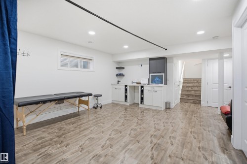 Wood-finish flooring throughout, recessed lighting, built-in cabinetry, and a bright window with blinds - 1523 36 Avenue Nw, Edmonton, AB 