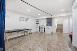 Wood-finish flooring throughout, recessed lighting, built-in cabinetry, and a bright window with blinds - 