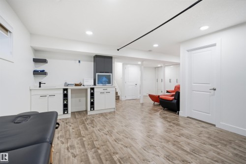 Recessed lighting, wood-finish flooring, built-in cabinetry with integrated shelving, and a wall-mounted faucet - 1523 36 Avenue Nw, Edmonton, AB 