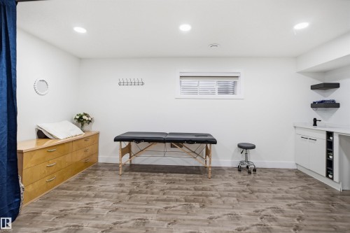 Recessed lighting, wood-finish flooring, built-in cabinetry, window with blinds, and a wall-mounted coat rack - 1523 36 Avenue Nw, Edmonton, AB 