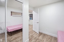 Wood-finish flooring, white interior doors, and a mirrored closet door - 