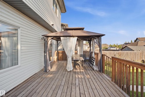 Spacious wood deck with a built-in gazebo, privacy curtains, and wood railings - 1523 36 Avenue Nw, Edmonton, AB 