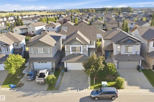 Two-story residence featuring an attached garage, paved driveway, and mature front yard landscaping - 1523 36 Avenue Nw, Edmonton, AB 