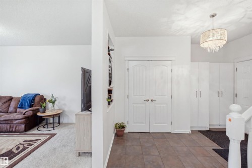 Tile flooring entry with double panel doors, built-in storage cabinetry, and a tiered chandelier - 1523 36 Avenue Nw, Edmonton, AB 