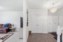 Tile flooring entry with double panel doors, built-in storage cabinetry, and a tiered chandelier - 