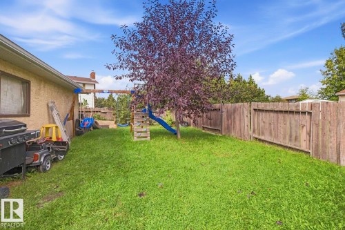 Expansive grassy yard with mature trees and wood fencing - 3216 138 Avenue Nw, Edmonton, AB 