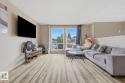 Spacious room featuring wood-finish flooring, light neutral wall paint, and multiple windows - 
