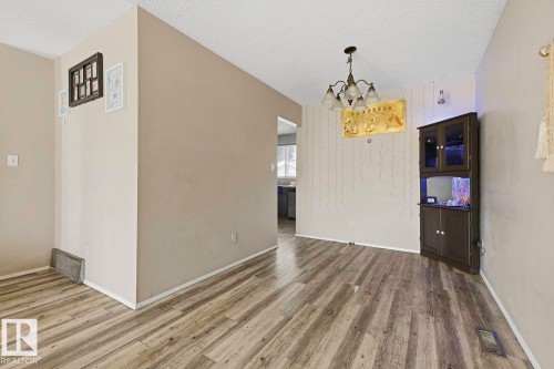 Wood-finish flooring throughout, vaulted ceiling, and a traditional chandelier - 3216 138 Avenue Nw, Edmonton, AB 