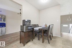 Archway entry, wood-finish flooring, ceramic tile flooring, built-in cabinetry, and a contemporary chandelier - 