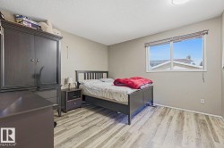 Wood-finish flooring with a large window and a ceiling-mounted light fixture - 