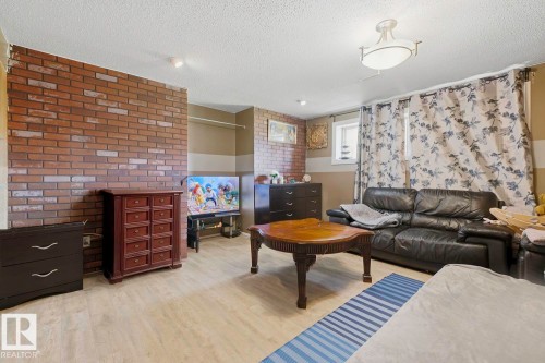 Brick accent wall, wood-finish flooring, recessed ceiling lighting, and a drum-style ceiling fixture - 3216 138 Avenue Nw, Edmonton, AB 