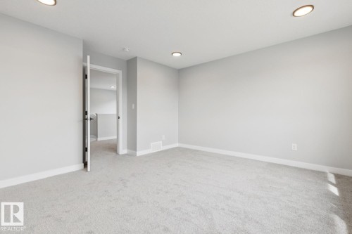Recessed ceiling lighting, light gray wall paint, light gray carpeting, and white trim - 72 Maple Crescent, Gibbons, AB 