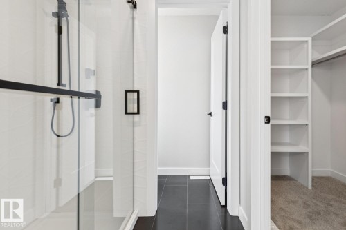 Walk-in shower with black-finish fixtures and clear glass enclosure - 72 Maple Crescent, Gibbons, AB 