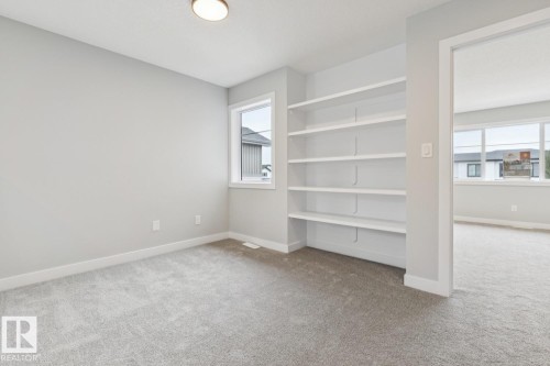 Recessed built-in shelving, light gray wall paint, light gray carpet, single window, and flush mount lighting - 72 Maple Crescent, Gibbons, AB 