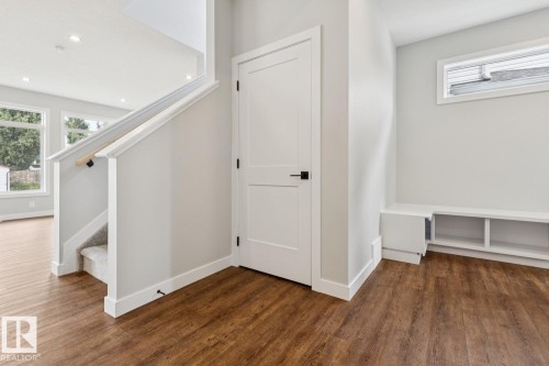 Wood-finish flooring throughout, white trim, recessed lighting, and a built-in storage bench with an upper window - 72 Maple Crescent, Gibbons, AB 