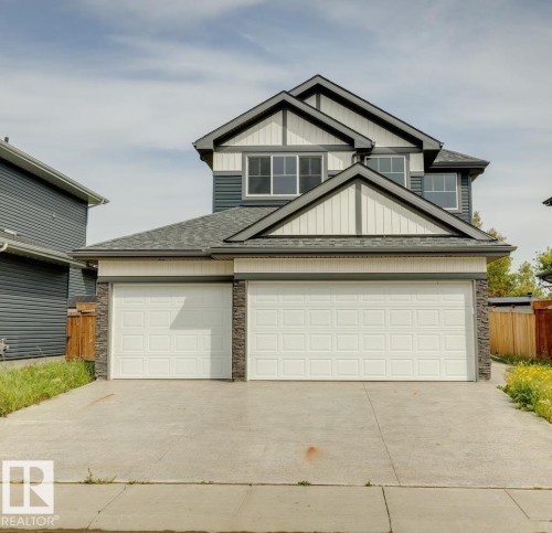 Two-story exterior with dark gray siding and white trim accents - 36 Maple Crescent, Gibbons, AB 