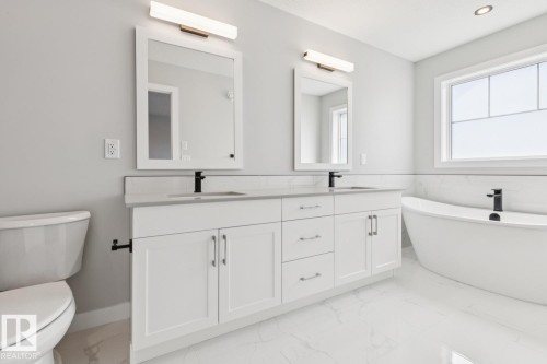 Dual vanity with white cabinetry, matte black fixtures, and light-toned countertops - 36 Maple Crescent, Gibbons, AB 
