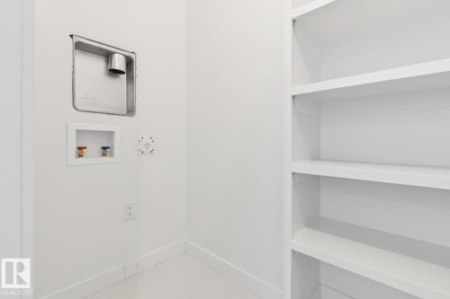 Built-in shelving, white walls, and utility hookups - 36 Maple Crescent, Gibbons, AB 