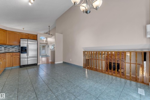 Kitchen with wood cabinetry, stainless steel refrigerator, and tiled backsplash - 9722 157 Street Nw, Edmonton, AB 