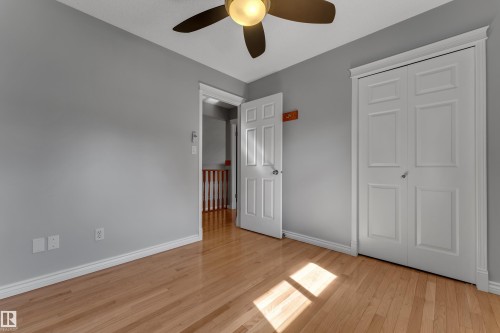 Hardwood flooring, ceiling fan with integrated lighting, white trim, and a bi-fold closet - 9722 157 Street Nw, Edmonton, AB 
