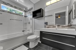 Built-in vanity with integrated sink, dark wood-finish cabinetry, and a full-width mirror - 
