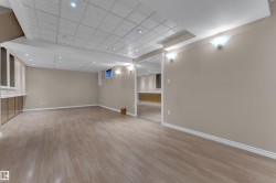 Expansive room with wood-finish flooring, recessed lighting, and neutral wall tones - 