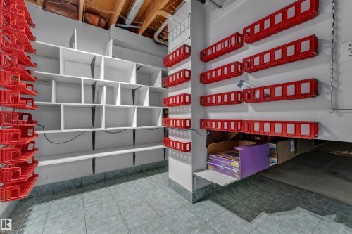 Extensive built-in shelving with multiple cubbies, additional wall-mounted storage units, and tiled flooring - 9722 157 Street Nw, Edmonton, AB 