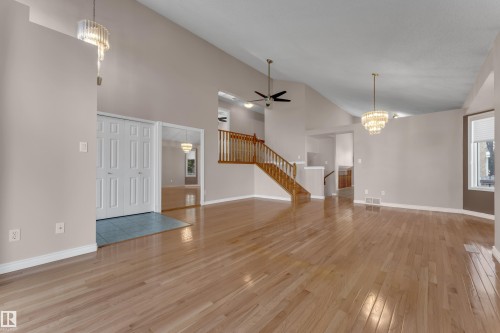 Vaulted ceilings, wood-finish flooring, two decorative chandeliers, a wood staircase, and an entryway with tiled flooring - 9722 157 Street Nw, Edmonton, AB 