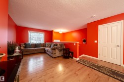 Hardwood-finish flooring, white trim, and a white paneled door - 