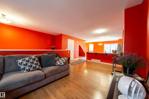 Hardwood flooring extending throughout, a breakfast bar with wood-finish countertop, and a built-in kitchen sink - #31 460 Hemingway Rd Nw, Edmonton, AB 