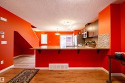 Kitchen with wood-finish flooring, stainless steel appliances, and a mosaic tile backsplash - 