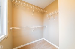 Carpeted room with multiple wire shelving units and a single window - 