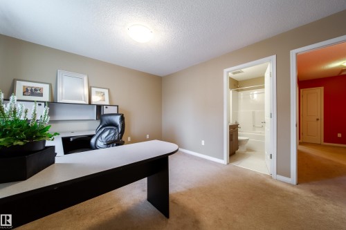 Carpeted flooring throughout, neutral wall paint, and a built-in desk with overhead shelving - #31 460 Hemingway Rd Nw, Edmonton, AB 