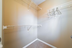 Walk-in closet with wire shelving, integrated hanging rods, and neutral-toned carpeting - 