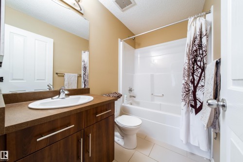 Wood-finish vanity with an integrated sink, laminate countertop, and chrome faucet - #31 460 Hemingway Rd Nw, Edmonton, AB 